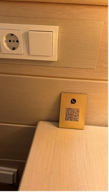 【写真10】ホテルの部屋の撤去された電話と代わりのVoIPアプリのQRコード