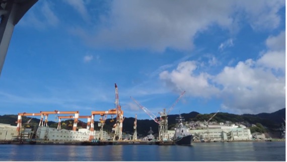 【写真2】長崎港沿岸の造船所。巨大なクレーン群が軍艦島へ向かう航路の始まりを告げる。