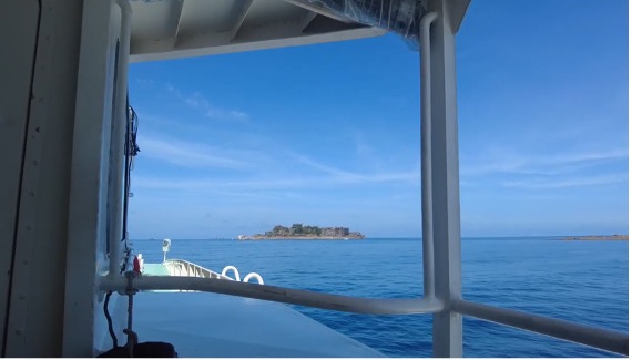 【写真3】軍艦島の姿が遠く視界に入ると、にわかに船内が沸き立つ。